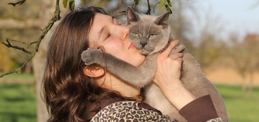 Cat parent kisses her cat