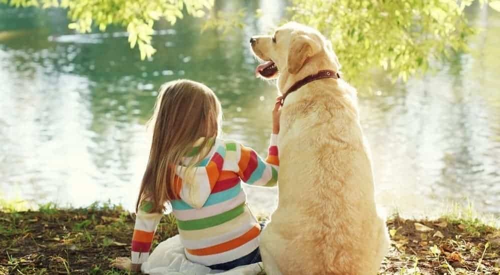 Girl and dog by lake